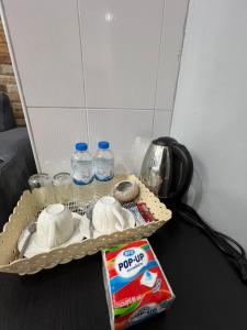 パトンビーチにあるPMS Guest House Patongの牛乳と水の入った箱が置かれたトレイのあるテーブル