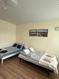 a bedroom with two beds and a clock on the wall at Apartament u Tereni in Chorzów