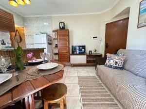 a living room with a couch and a table at Apto no Boqueirão, 5 min da praia + Wi-Fi! in Praia Grande