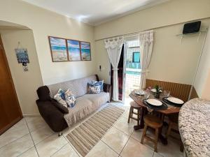 a living room with a couch and a table at Apto no Boqueirão, 5 min da praia + Wi-Fi! in Praia Grande