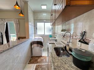 a kitchen with a sink and a counter top at Apto no Boqueirão, 5 min da praia + Wi-Fi! in Praia Grande +57 photos