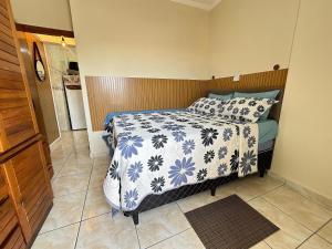 a bedroom with a bed with a blue and white comforter at Apto no Boqueirão, 5 min da praia + Wi-Fi! in Praia Grande