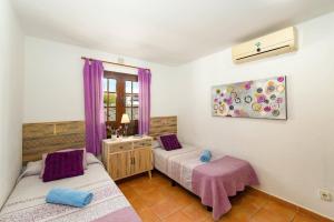 2 camas en una habitación con cortinas moradas en Villa Flamingo by Villa Plus, en Playa Blanca 32 fotos más