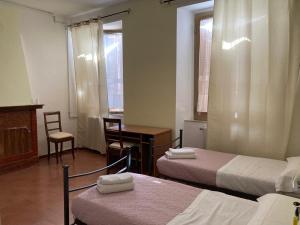 a room with two beds and a table and a desk at Angolo Di Michele e Sergio in Foligno +17 photos