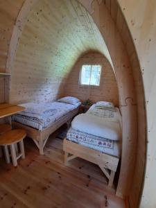 two beds in a log cabin with a window at Cabane Perce Neige - Gavarnie in Gèdre