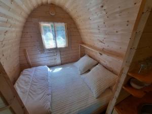 a bed in a wooden cabin with a window at Cabane Perce Neige - Gavarnie in Gèdre