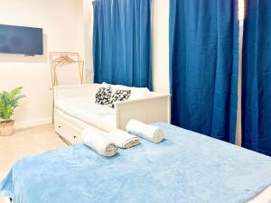 zwei Betten in einem Zimmer mit blauen Vorhängen in der Unterkunft COSTA by Hawkins BajoA in Algeciras