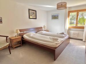 a bedroom with a large bed in a room at Chesa Foulla Rosa - 6 pax in Celerina