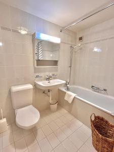 a bathroom with a toilet and a sink and a tub at Chesa Foulla Rosa - 6 pax in Celerina