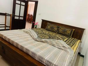 a bed with a wooden frame and pillows on it at Casa del Mar in Ahungalla