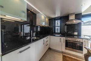 a kitchen with white cabinets and black counter tops at The Yard in Franschhoek