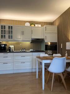 Una cocina con gabinetes blancos y una mesa y sillas. en Ferienwohnung Altstadt Perle_ 15164, en Leer