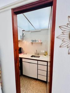 una piccola cucina con lavandino e specchio di Apartamento Torreón Cerca del mar y Güemes a Mar del Plata