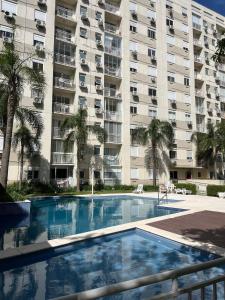 einem Pool vor einem großen Apartmenthaus in der Unterkunft Apartamento suíte com estacionamento in Porto Alegre