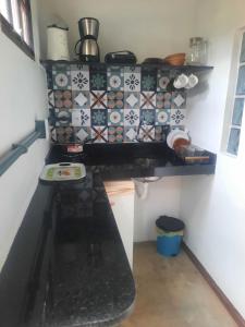 a kitchen with a stove and a counter top at Suíte com Cozinha Compacta in Guarapari