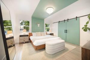 Un dormitorio con una gran cama blanca y un taburete blanco. en Pura Vida Villa Miami Luxury Stay Pool & Hot Tub, en North Miami 23 fotos más