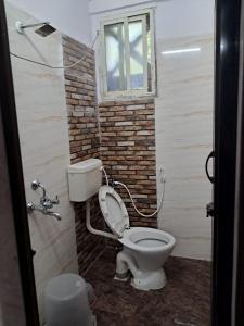 a bathroom with a toilet and a window at Nayath Serviced Apartments, Homely Stay for Families since 2011 Close to Bus, Railway Stations, Near to Reliance Mart, Srinivasam complex and many Restaurants Fully Furnished Kitchen Pet Friendly in Tirupati