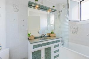a white bathroom with a sink and a shower at L'Escapade - Port Murano in Le Barcarès