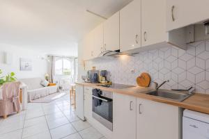 a kitchen with white cabinets and a sink at L'Escapade - Port Murano in Le Barcarès