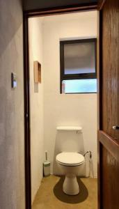 a bathroom with a toilet and a window at NIANI HYENA chalet in Hoedspruit