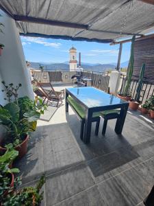 a table on a patio with a lighthouse in the background at La casa de Paco y Ana in Pitres