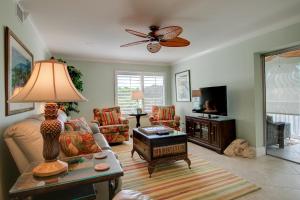 una sala de estar con un sofá y una mesa en Sanibel Surfside 226, en James Cipriani Heliport