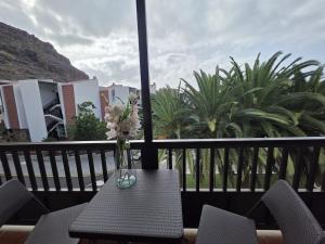 a vase of flowers sitting on a table on a balcony at Miel de Guarapo Apartment in La Gomera