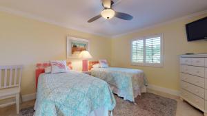 Un dormitorio con dos camas y un ventilador de techo. en Sanibel Surfside 226, en James Cipriani Heliport 14 fotos más