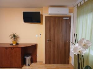 a room with a door with a television on the wall at Apartments Orange in Uherské Hradiště