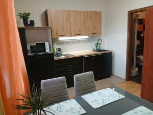 a kitchen with a table with chairs and a microwave at Apartments Orange in Uherské Hradiště