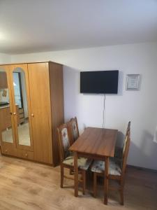 a dining room with a table and chairs and a television at Ubytovanie Otília in Zuberec