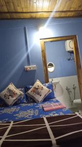 a bedroom with a bed with pillows and a mirror at Sylvan homestay mawlynnong in Mawlynnong