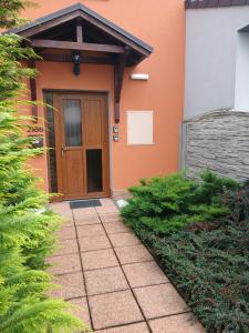 a house with a brown door and a sidewalk at Apartments Orange in Uherské Hradiště