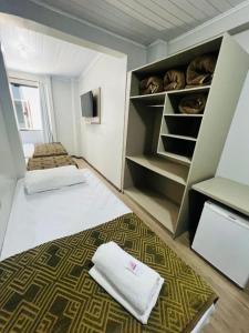 a small room with two beds and a closet at Hotel Zata - Econômico in Criciúma +101 photos