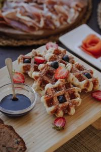 a wooden cutting board with waffles and fruit on it at Hotel Palacio de Caranceja in Reocín