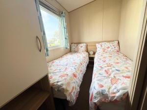 ein kleines Schlafzimmer mit zwei Betten und einem Fenster in der Unterkunft Park Dean Resorts Premium plot with Mountain view & Decking in Abergele + 6 Fotos
