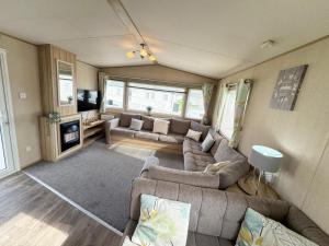 ein großes Wohnzimmer mit Sofas und Fernseher in der Unterkunft Park Dean Resorts Premium plot with Mountain view & Decking in Abergele