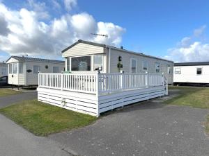 ein großes weißes Mobilheim mit Veranda in der Unterkunft Park Dean Resorts Premium plot with Mountain view & Decking in Abergele