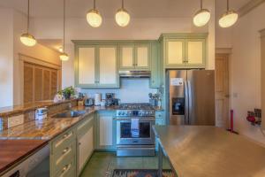 a kitchen with blue cabinets and a stainless steel refrigerator at Roe Parker House in Hood River +14 photos