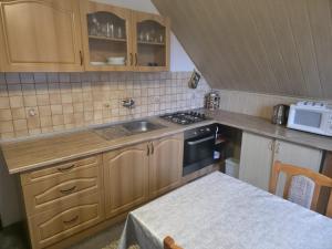 a small kitchen with a sink and a microwave at Ubytovanie Otília in Zuberec