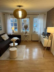una sala de estar con un sofá y una mesa en Ferienwohnung Altstadt Perle_ 15164, en Leer