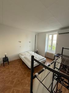 ein Schlafzimmer mit einem Bett in einem Zimmer mit einem Fenster in der Unterkunft Chambres individuelles dans maison familiale in Vierzon