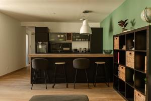 a kitchen with a bar and stools in a room at Le Derby in Valence