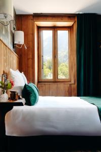 a bedroom with a large bed and a window at Auberge des Gorges - Restaurant Gastronomique & Chambres in Servoz