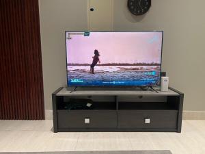 a flat screen tv sitting on a tv stand at Quiet and comfortable apartment near Rakka Sea in Dammam
