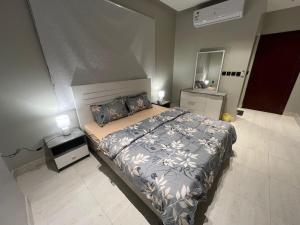 a bedroom with a large bed and two lamps at Quiet and comfortable apartment near Rakka Sea in Dammam