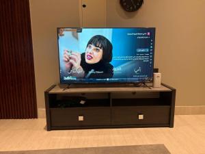 a flat screen tv sitting on a entertainment center at Quiet and comfortable apartment near Rakka Sea in Dammam +7 photos