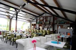 un restaurante con mesas y sillas blancas y una lámpara de araña en Dunez men only resort en Drunen