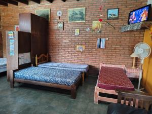 a room with two beds and a brick wall at El Paraíso in Necochea