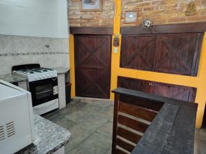 a kitchen with two wooden doors and a stove at El Paraíso in Necochea +5 photos